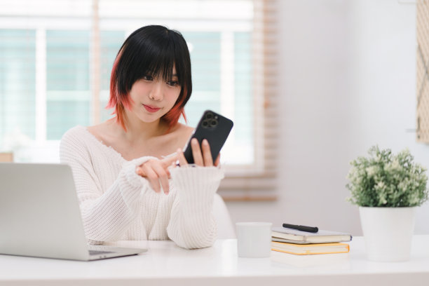 在家里舒适的客厅里，一位漂亮的年轻女子用灵巧的手指全神贯注地在智能手机上发信息。图片下载