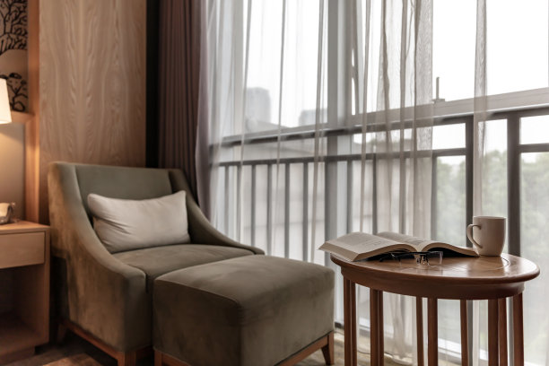 靠窗的舒适沙发，圆桌上有一本打开的书图片下载