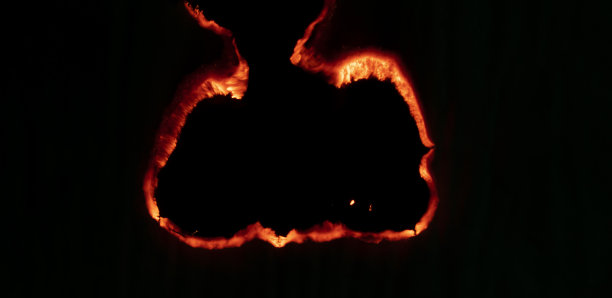 燃烧的纸，在黑色背景上发光的纸边图片下载