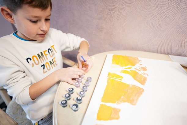 左手男孩正在家里用水粉画数字。舒适区。图片下载