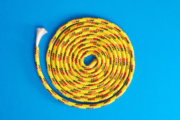 长而结实的绳子在蓝色背景上卷成一卷。图片下载