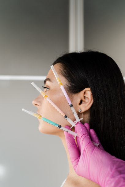 拿着维他命鸡尾酒注射器注射的女孩特写。注射维生素、酶、激素和植物提取物，使皮肤恢复活力，紧致皮肤，去除多余脂肪。图片下载