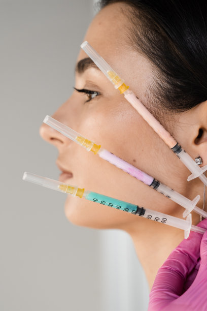 拿着维他命鸡尾酒注射器注射的女孩。注射维生素、酶、激素和植物提取物，使皮肤恢复活力，紧致皮肤，去除多余脂肪。图片下载