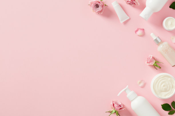 一套天然化妆品护肤品与玫瑰花瓣在柔和的粉红色背景图片下载