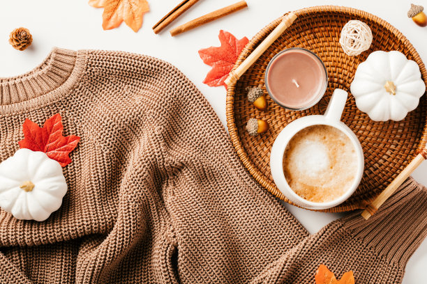 棕色针织衫，一杯咖啡，枫叶，白底南瓜。秋天，秋平铺构图。图片下载