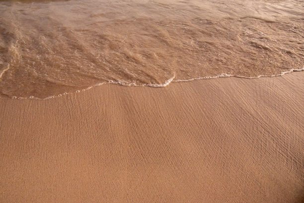 沙滩岸线，白色的海浪拍打着岸线。图片下载