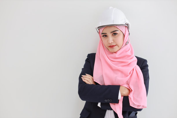 穿着蓝色西装的年轻穆斯林亚洲女工程师在工作室自信微笑。粉色头巾美女的白色背景肖像。广告肖像概念。图片下载