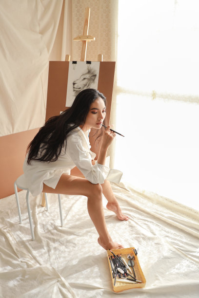 穿白衬衫的长裙女艺术家一边用铅笔画画一边思考(女性生活方式概念)图片下载