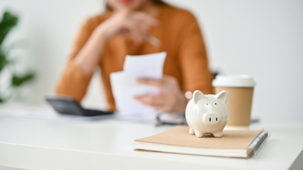 桌子上的储蓄罐的特写图片，一个女人在计划她每月的开销图片下载
