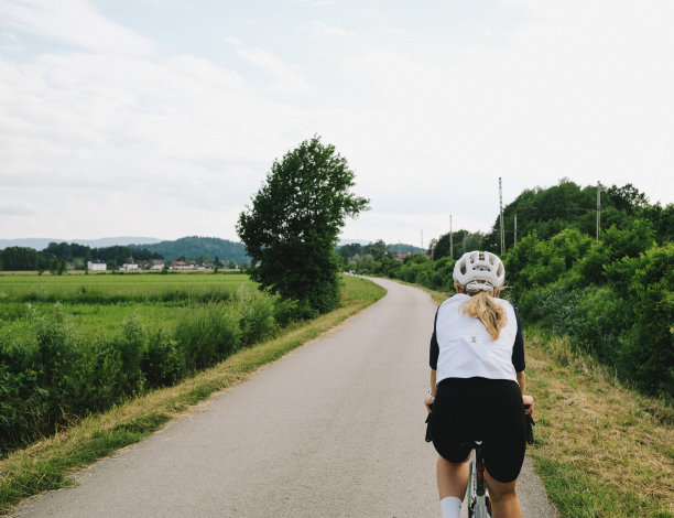 年轻女子在乡间小路上骑着砂石自行车图片下载