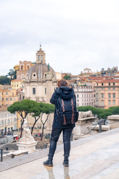 无法辨认的全身拉丁女旅行者，背着背包，在意大利罗马的广场上欣赏着祖国祭坛，享受着令人惊叹的雄伟城市景观图片下载