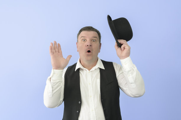 穿着复古西装的惊讶男人。圆顶礼帽，白衬衫，黑背心。浅蓝色背景。图片下载