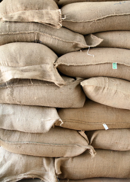 仓库里一堆装着谷物的棕色粗麻袋图片下载
