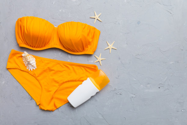 女子泳装和沙滩配饰平铺上视图彩色背景夏季旅游概念。比基尼泳衣，草帽和高跟鞋。复制空间俯视图图片下载