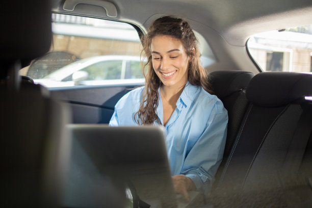 年轻女子坐在汽车后座上图片下载