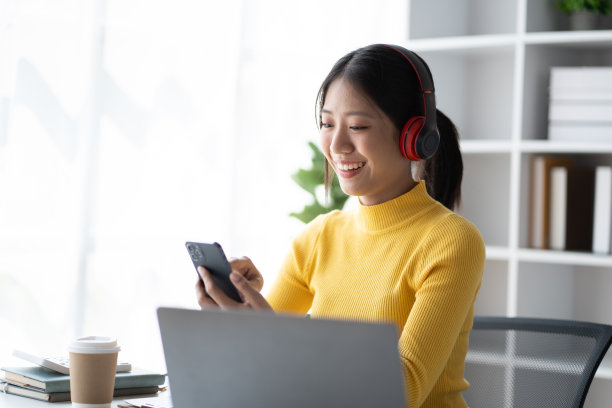 年轻漂亮的女商人喜欢在空闲时间听音乐。图片下载