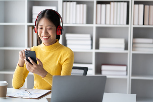 年轻漂亮的女商人喜欢在空闲时间听音乐。图片下载