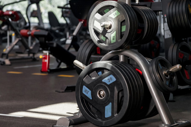 现代健身房内部有运动器材运动杠铃杆架。新的健身中心库存的体育赛事和训练练习。概念运动设计背景。复制文本空间，横幅图片下载