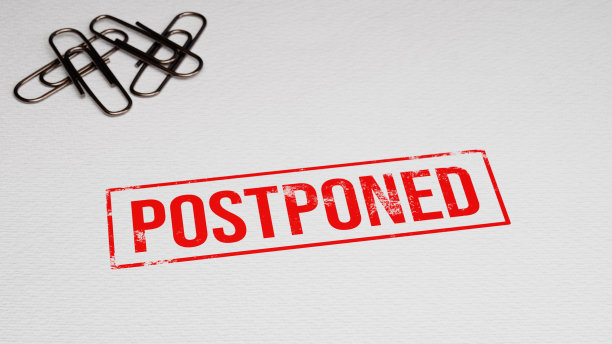 延期的橡皮图章在纸上，背景是纸别针。三维演示图片下载