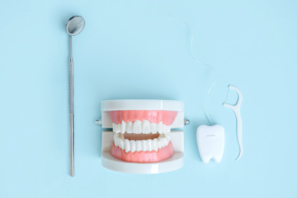 牙齿和牙科器械和牙科保健产品的模型在蓝色背景顶部视图复制空间平放。牙齿护理，口腔卫生和健康的理念。图片下载