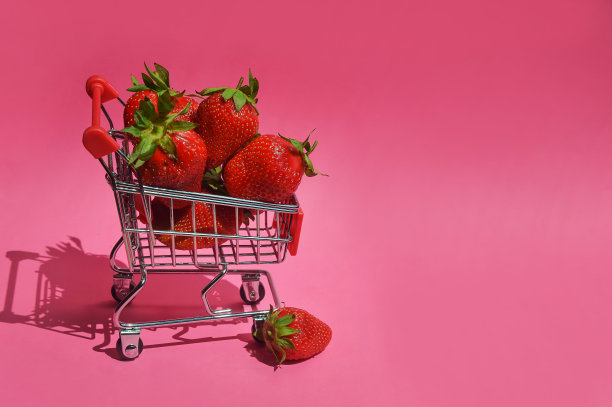 购物车里的熟草莓。新鲜的浆果。设计背景图片下载