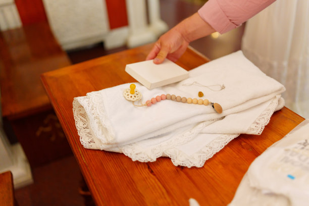 一条白毛巾和一个婴儿奶嘴放在长凳上。图片下载