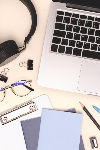 笔记本电脑，耳机，眼镜和文具，米色背景。图片下载