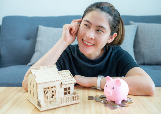 幸福的亚洲女人正在考虑存钱买新房子。图片下载
