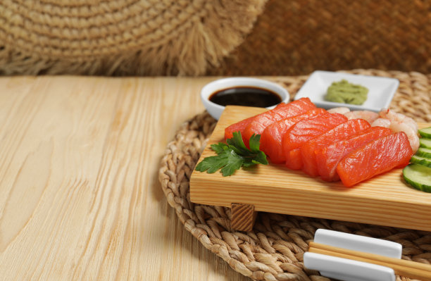 美味的三文鱼和虾生鱼片，配上黄瓜、欧芹和酱油，摆在木桌上。文本空间图片下载