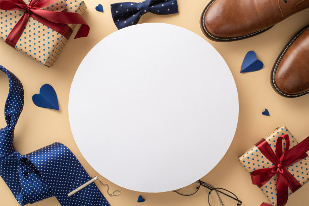 愉快的父亲节庆祝灵感。心形、绅士配饰和礼品盒的自上而下的视图显示在米色背景上，空白的圆圈显示文字或广告图片下载
