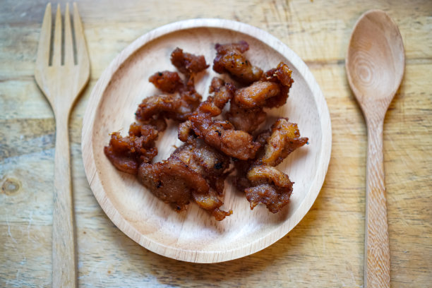 一张特写照片显示了餐桌上木盘上的即食炸五花肉。图片下载