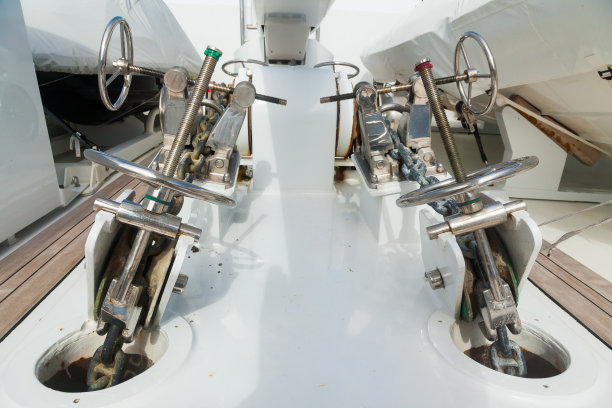 豪华游艇柚木甲板的船首，配有不锈钢绞车和锚链固定机构。图片下载