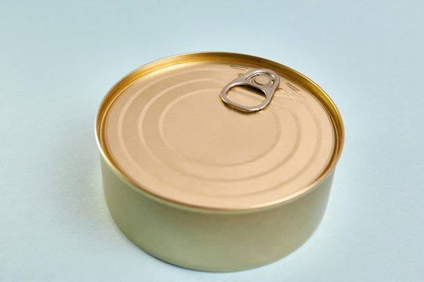 蓝色背景的金属罐子里装着罐头鱼。食品长期储存的概念。图片下载