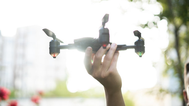 男性手持无人机在空中飞行图片下载