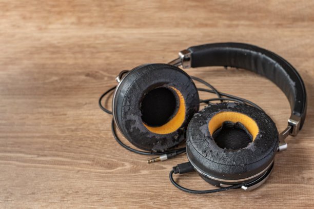 一张小木桌上的旧耳机特写。电气设备和电气装置维修的概念。高品质聆听音乐的耳机图片下载