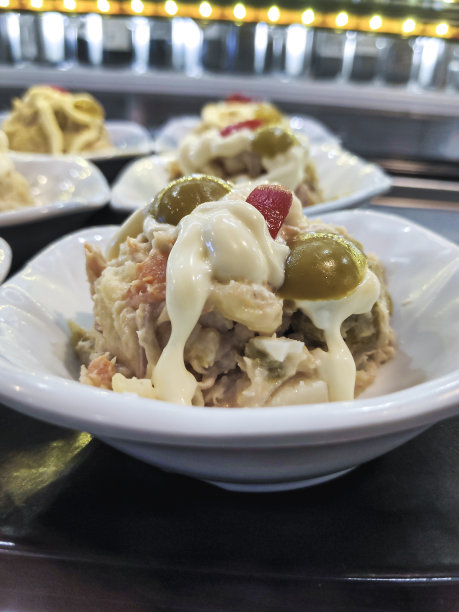 一种典型的西班牙餐前小吃，由蛋黄酱、土豆、西红柿、金枪鱼、橄榄和辣椒在吧台上做成的开胃菜，被称为俄罗斯沙拉、西班牙土豆沙拉或奥利维尔沙拉。图片下载