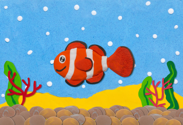 橙色和白色的小丑鱼由橡皮泥在水下背景图片下载