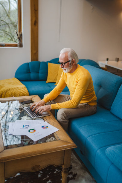 一位年长的白种人在家里用笔记本电脑工作图片下载