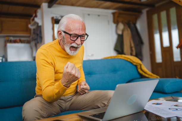 一位年长的白种人在家里用笔记本电脑工作图片下载