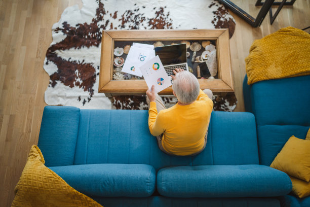 一位年长的白种人在家里用笔记本电脑工作图片下载