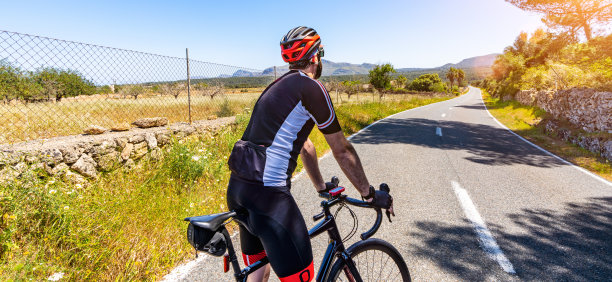 成熟的成年人骑着赛车在地中海风景海岸公路上爬山。图片下载