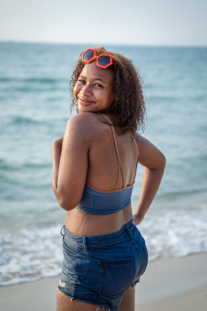 一个非洲女孩在一个阳光明媚的暑假在海滩上玩得很开心。图片下载