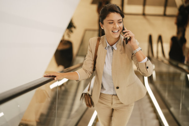 女商人在商场使用自动扶梯楼梯。图片下载