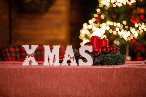 质朴的木制字母拼出“XMAS”这个词，放在餐桌上作为装饰图片下载