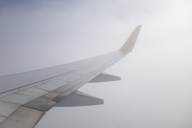 飞机的机翼在天空的云层上飞行图片下载
