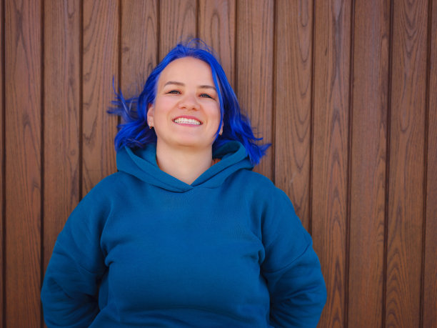 身穿浅蓝色大号卫衣和牛仔裤的女性图片下载