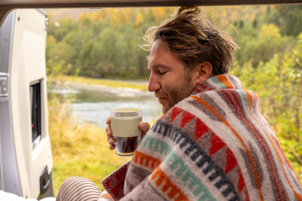 一个年轻人在他的露营车里醒来，他向外望去图片下载