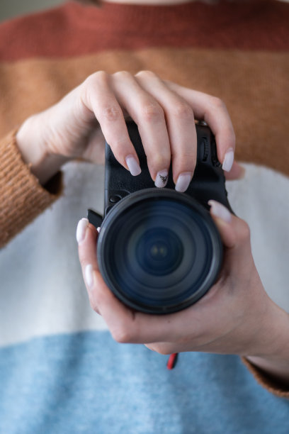 摄影师站着准备工作，在摄影师的手中有一个相机。图片下载