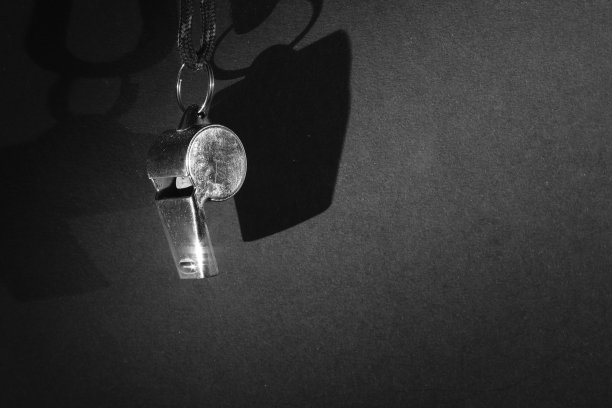 足球裁判或教练的哨声。近距离的黑白照片，象征着足球产业的黑暗面图片下载