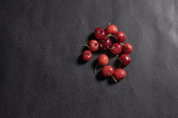 甜美的红樱桃散落在黑色的背景上。前视图。水果的背景。图片下载